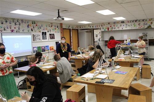 high school students painting in art room